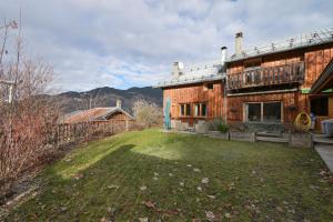 una grande casa in mattoni con un cortile di fronte di Chalet La Hulotte a Brides-les-Bains