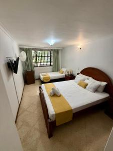 a bedroom with two beds and a television in it at Hotel Balcones De Malibu in Medellín