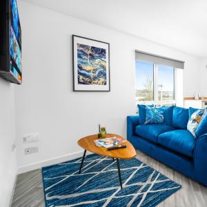 a living room with a blue couch and a table at Modern Two Bed Apartment - Sleeps 3 - WiFi & Parking Included 57C in Sleightholme