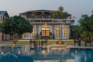 a house with a swimming pool in front of a house at Trideus The Wild Fraser Corbett in Rāmnagar