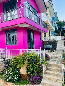 a pink house with flowers in front of it at Mia Homestay and Coffee in Bảo Lộc