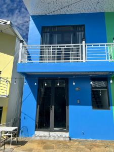 a blue building with a balcony and a door at Mia Homestay and Coffee in Bảo Lộc +1 photo