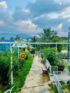 a garden with benches and trees and a bridge at Mia Homestay and Coffee in Bảo Lộc