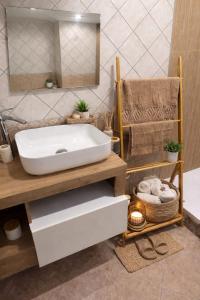 un bagno con un lavandino bianco e uno specchio di Le Stanze Della Castellana a Bosa