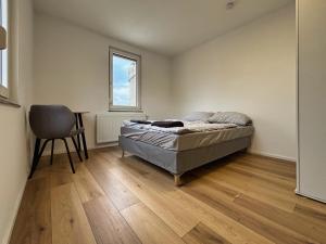 a bedroom with a bed and a chair in it at HAVENU Ludwigsburg Mitte in Ludwigsburg +6 photos