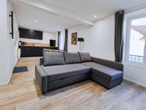 ein Wohnzimmer mit Sofa und eine Küche in der Unterkunft Vert Bocage Briard - Freedomus Marne-la-Vallée in Esbly