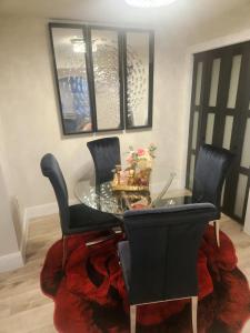 een eetkamer met een glazen tafel en zwarte stoelen bij Modern Basement Suite • King Bed & 100” TV in Shrewsbury +9 foto's