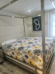 een bed met een bloemdekbed in een slaapkamer bij Modern Basement Suite • King Bed & 100” TV in Shrewsbury