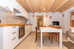 una cucina e una sala da pranzo con tavolo e sedie di Ciasa al Caselo a Falcade Altre 14 foto