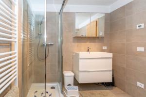 un bagno con doccia, lavandino e WC di Ciasa al Caselo a Falcade