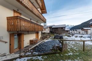 una casa con balcone in legno e tavolo di Ciasa al Caselo a Falcade