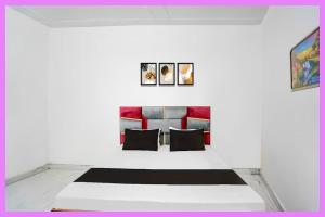 a living room with a couch and paintings on the wall at Hotel Kavmira Premium Inn in Puri