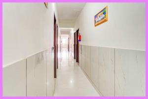 a hallway with white walls and a picture on the wall at Hotel Kavmira Premium Inn in Puri
