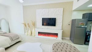 a living room with a fireplace with a tv above it at Stylish Furnsihed Apartments Opposite Five Hotel In JVC in Dubai