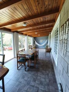eine Veranda mit Holzdecke und einem Tisch und Stühlen in der Unterkunft El Algarrobo Casa de campo en Cabalango in Cavalango