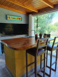 eine Küche mit einer Holztheke und einem Tisch und Stühlen in der Unterkunft El Algarrobo Casa de campo en Cabalango in Cavalango