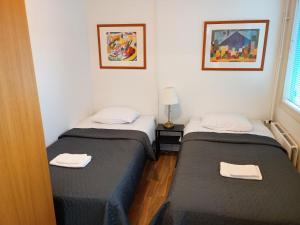 due letti singoli in una stanza con finestra di Hotel 24 - Apartments a Kemi