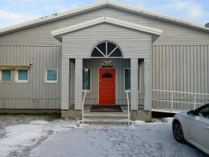 una casa con una porta rossa e una macchina parcheggiata di fronte di Hotel 24 - Apartments a Kemi