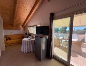 ein Wohnzimmer mit Kühlschrank und einem Tisch mit Sofa in der Unterkunft Villa Marianna in Alghero