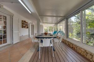 een eetkamer met een tafel en een aantal ramen bij Villa das Buganvilias by Delilah Collection in Albufeira