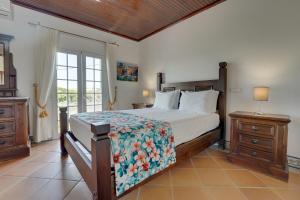 een slaapkamer met een bed en twee nachtkastjes en een raam bij Villa das Buganvilias by Delilah Collection in Albufeira +29 foto's