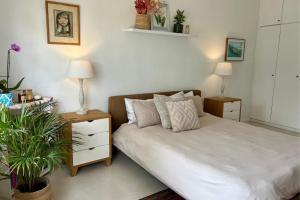 een slaapkamer met een bed met twee nachtkastjes en twee lampen bij Kommetjie Mountain Oasis in Kommetjie