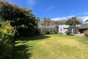 een tuin van een huis met een tuin van gras bij Kommetjie Mountain Oasis in Kommetjie