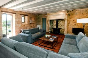 ein Wohnzimmer mit blauen Sofas und einem Kamin in der Unterkunft Charming Houses With Pool In Perigord in Sainte-Croix-de-Beaumont