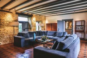 ein Wohnzimmer mit einem blauen Sofa und einem Tisch in der Unterkunft Charming Houses With Pool In Perigord in Sainte-Croix-de-Beaumont + 32 Fotos