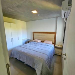 um quarto com uma cama com lençóis azuis e almofadas cor-de-rosa em Dpto a 12 minutos del Eje Corporativo em Luque mais 29 fotografias