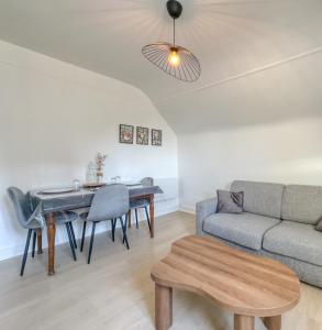 uma sala de estar com um sofá e uma mesa em L'Oscar Imperial em Compiègne mais 17 fotografias