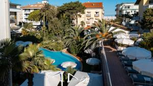 ein Resort mit Swimmingpool und Sonnenschirmen in der Unterkunft Park Hotel Pineta Boutique Hotel in Caorle