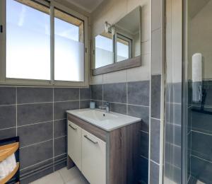 um banheiro com pia e espelho em L'Oscar Imperial em Compiègne