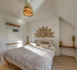 um quarto com uma cama grande e uma luz pendente em L'Oscar Imperial em Compiègne