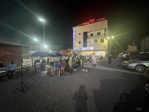 un groupe de personnes assises à des tables la nuit dans l'établissement HOTEL COMFORT INN & SUITEs, à Yaoundé