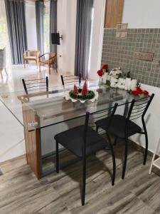 ein Esszimmer mit Glastisch und Stühlen in der Unterkunft Shalom breaze in Gettapola