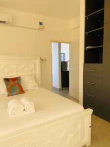 une chambre avec un lit blanc avec des serviettes dessus dans l'établissement Coral Sands - BriSta Stays, à Mombasa
