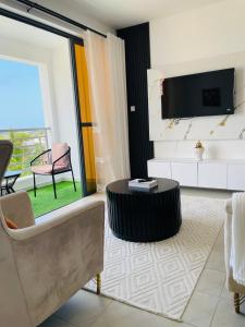 un salon avec un canapé et une télévision dans l'établissement Coral Sands - BriSta Stays, à Mombasa