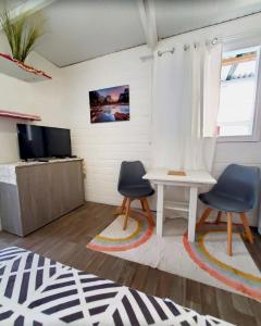 een woonkamer met twee stoelen en een tafel bij Appartement Oslo in Sainte-Anne