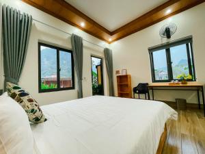a bedroom with a white bed and two windows at The Sam Home in Nguyên Ngoại +56 photos