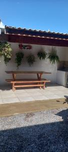 een houten bank naast een muur met planten bij Casa in Bonito