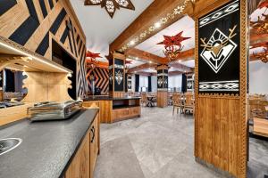 a kitchen with wooden cabinets and a dining room at Grand Regle Resort & SPA in Poronin