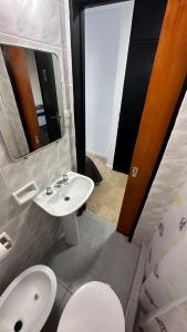 un bagno con lavandino, WC e specchio di Hotel Araucano a Mar de Ajó