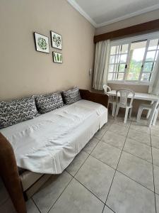 un soggiorno con un letto, un tavolo e delle sedie di Amarilis Flat Service a Riviera de São Lourenço