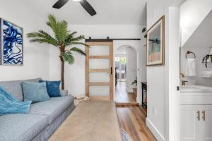 a living room with a couch and a palm tree at La Barra #101.5 in St. Pete Beach +64 photos
