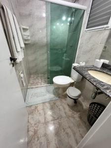 un bagno con doccia, WC e lavandino di Amarilis Flat Service a Riviera de São Lourenço
