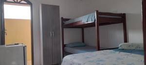 Un dormitorio con dos literas y una cama. en Residencial Lage Suíte 05-A (Casal+01Beliche), en Porto Seguro 3 fotos más