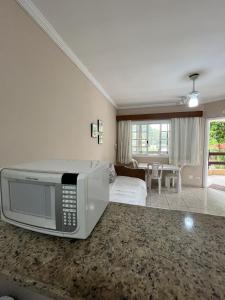 un soggiorno con un forno a microonde appoggiato sul pavimento di Amarilis Flat Service a Riviera de São Lourenço Altre 18 foto