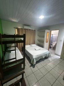 a bedroom with a bunk bed and a bathroom at Pipa Hotel Pe na Areia in Pipa +13 photos