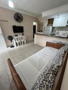 una camera da letto con un letto e una cucina con un tavolo di Amarilis Flat Service a Riviera de São Lourenço